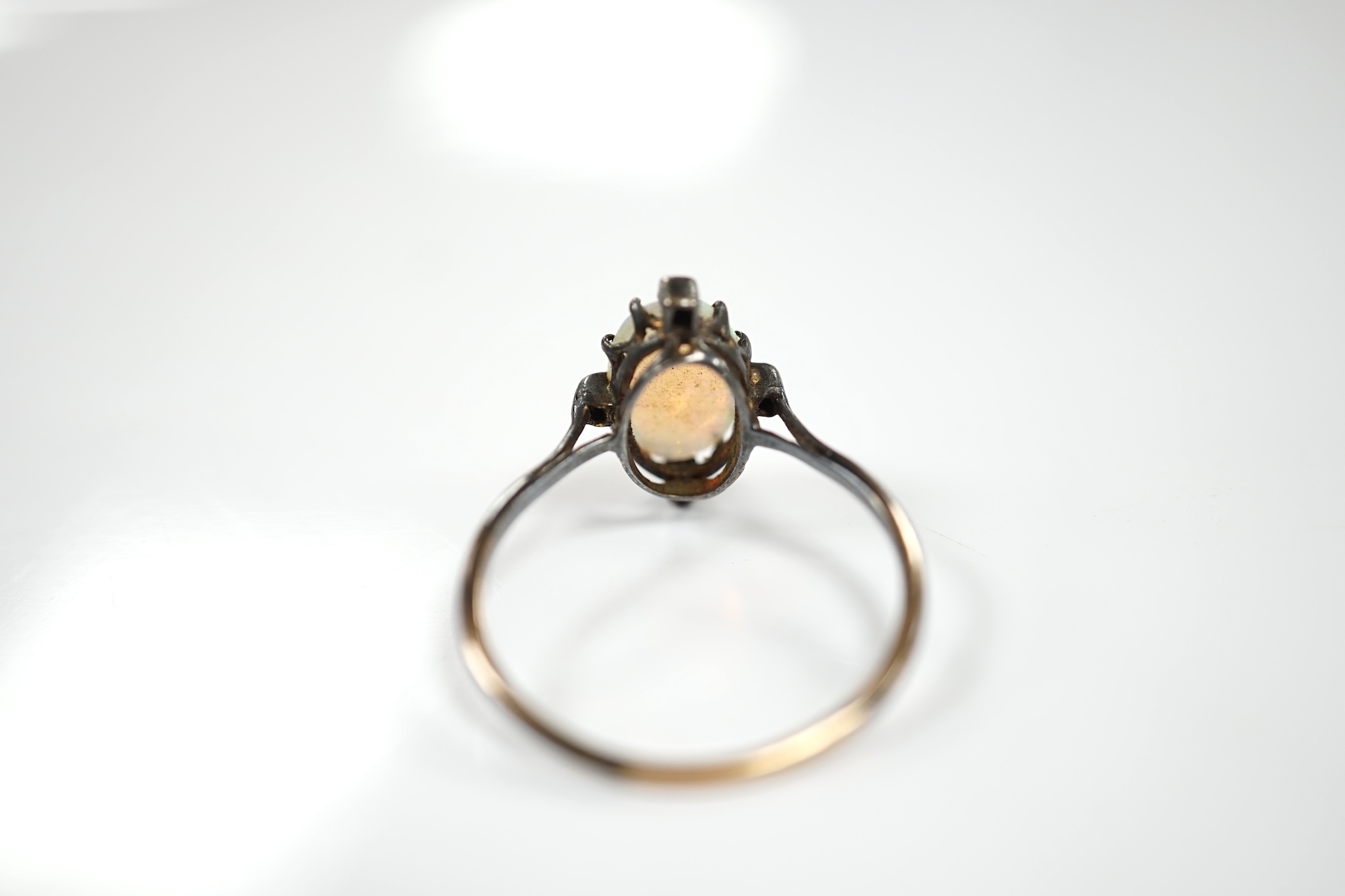 An antique, yellow and white metal, white opal and diamond set ring, size T, gross weight 2.1 grams. Condition - poor to fair